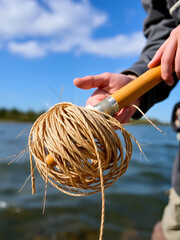 Coil of fly fishing rope, man hands holding rod