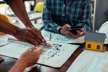 Architect checking blueprints on construction site Architects and engineers meet to discuss and check house plans to meet building and construction standards.