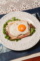 Close-up view of a breaded cutlet with fried egg on a restaurant table.