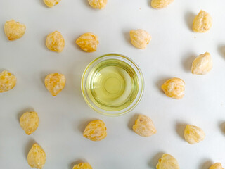 Candlenut oil or minyak kemiri on the bowl, is a natural ingredient for hair treatment