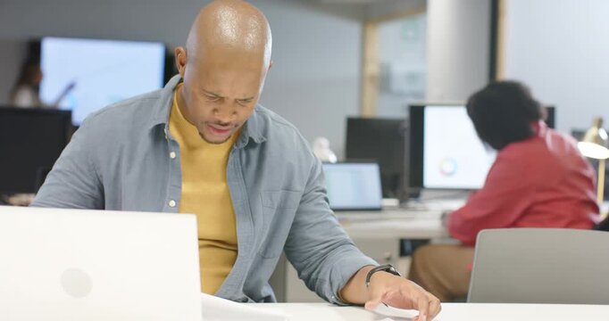 African American coworkers scanning reports and pointing at pie chart seeking clarification at desk