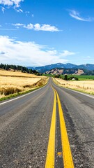 Fototapeta premium A long, straight road cuts through a rural landscape under a bright blue sky