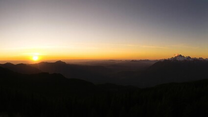 Fototapeta premium Sunrise over mountain peaks with clouds and golden sky