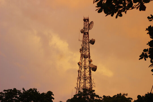 Tower listrik dengan beground matahari terbit dan awan oren yang indah