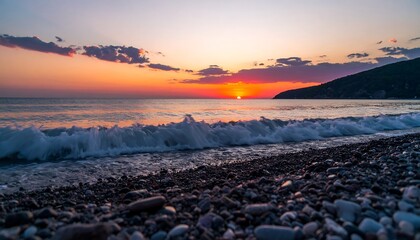 Vibrant sunset over calm sea, waves gently lapping a pebbled shore