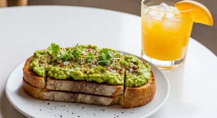 Avocado toast with microgreens and a glass of orange juice