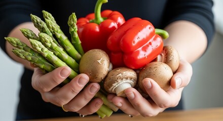 Hands holding fresh red bell peppers asparagus and mushrooms