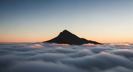 Silhouette of a pointed mountain peak above a sea of clouds at sunrise