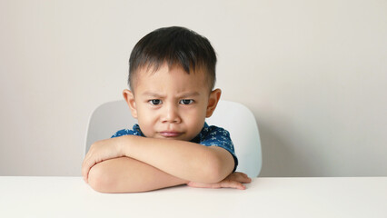 Asian little boy sleeping on a white table, accidentally sleeping without thinking much, on a white...