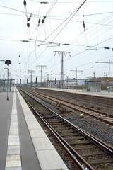 Fototapeta premium Empty Train Station Platform with Overhead Electric Cables