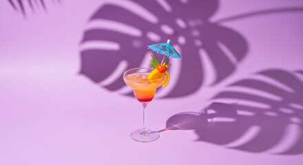 Tropical cocktail with umbrella and fruit garnish on purple background