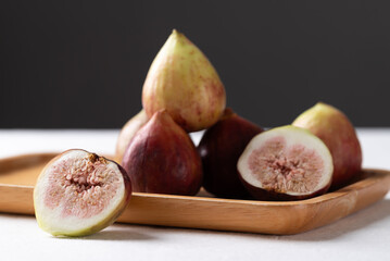 Fresh fig on with wooden plate on white and black background, Healthy fruit