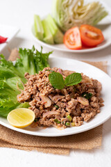 Local Thai food, Spicy minced pork salad (Larb Moo) eating with fresh vegetables 