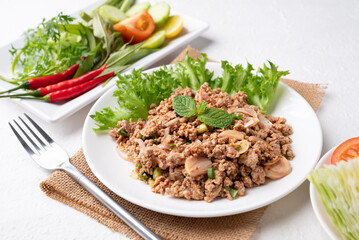 Local Thai food, Spicy minced pork salad (Larb Moo) eating with fresh vegetables on white background