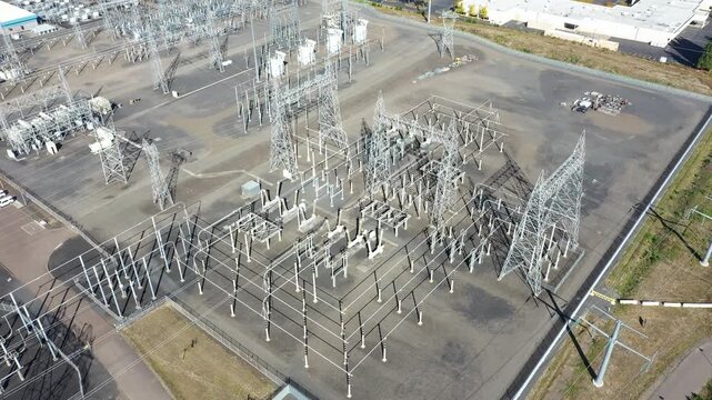 4K aerial drone footage of large electric power substation and high voltage power lines in Hillsboro Oregon, showing transmission towers, transformers, and distribution infrastructure from above