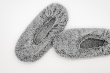 Fluffy gray home slippers isolated on white background. Bed shoes accessory footwear. Top view or flat lay, close-up.