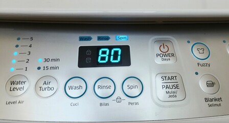 Details of the buttons on a top-loading washing machine with the spin mode on (80 minutes on process)