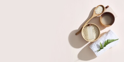 Composition with rice water and clean towel on light background with space for text, top view