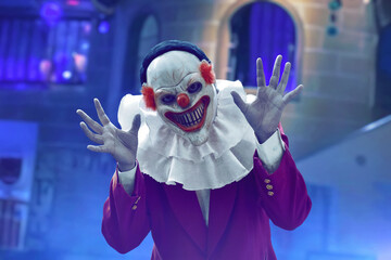 Man wearing scary clown mask on amusement park, Halloween theme