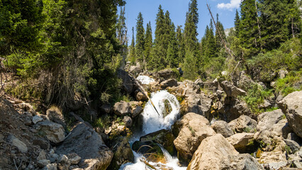 a waterfall among the rocks. a waterfall in the mountains. a river in the forest