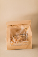 a sourdough bread in a paper brown bag on beige 