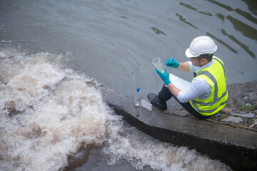 Naklejka premium Scientists are collecting samples of water released into canals by treatment ponds to examine the microscopic organisms that live in the water.