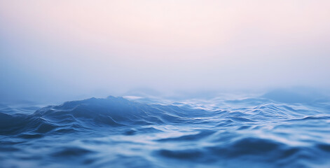Fototapeta premium Gentle ocean waves ripple and roll beneath a foggy sky at dawn creating a serene seascape.