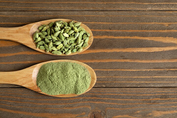 Spoons with cardamom spice and powder on wooden background