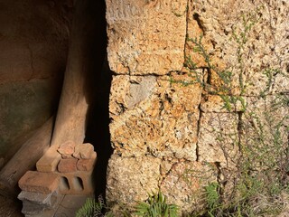 風化した石積みの壁と木材に差し込む光