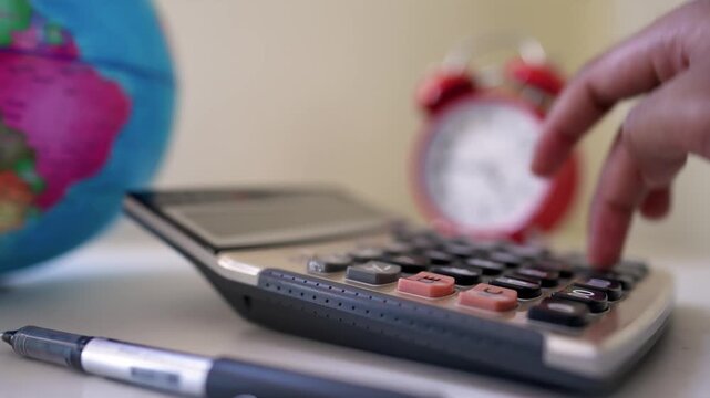 Calculator with hand pressing button and globe