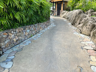 Stone lined garden pathway with lush foliage and rocks