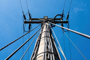 Electrical power distribution pole urban area photographic capture clear sky low angle infrastructure overview