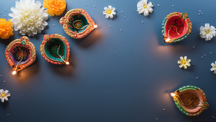 Obraz na płótnie Canvas Happy Diwali - Clay Diya lamps lit during Diwali, Hindu festival of lights celebration. Colorful traditional oil lamp diya on blue background