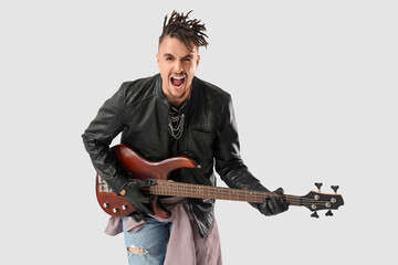 Cool young man with dreadlocks playing guitar on white background