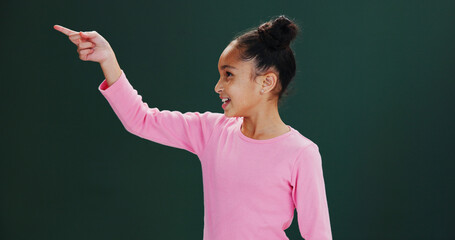 Studio, news and child with smile, pointing and happy for presentation, announcement or mockup...