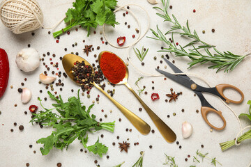 Composition with herbs, threads, scissors and spoons of spices on white grunge background