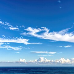 Vast expanse of a cerulean sky, dotted with wispy clouds, meeting the deep blue ocean