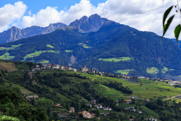 Panorama with castle Schloss Brunnenburg, vineyards, village Tirol (Dorf Tirol) and mountain summit Ifinger in South Tyrol, Italy