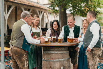 Friends in Bavaria Germany toast with beer mugs in a lively beer garden enjoying tradition culture...