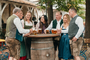 Happy men and women gather in a Bavarian beer garden clinking beer mugs celebrating friendship leisure and German culture with cheer