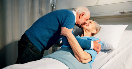 Kiss, visit and senior woman in hospital with husband for bonding, support or care in recovery. Retirement, marriage and elderly patient in ward bed with empathy for connection in medical clinic.