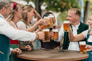 Friends clinking beer mugs in Bavarian beer garden celebrate leisure Oktoberfest German culture tradition friendship and festive lifestyle
