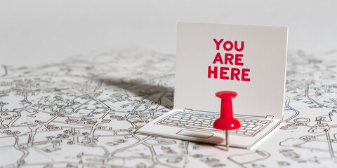 Obraz premium Red push pin on map with You Are Here sign indicating location 