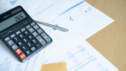 Closeup of calculator with 2026 and pen on reports, illustrating accounting, cost management, and strategic financial decisions.