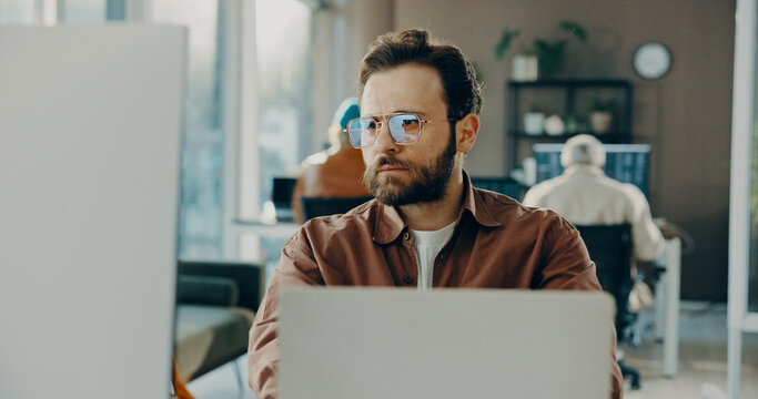 Reading, computer and business man in office for software development, online project or review. Laptop, serious or frontend developer with internet update, creative problem solving or website design