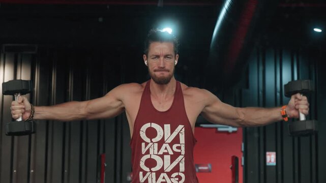 bodybuilder doing a dumbbell shoulder fly whilst listening to music
