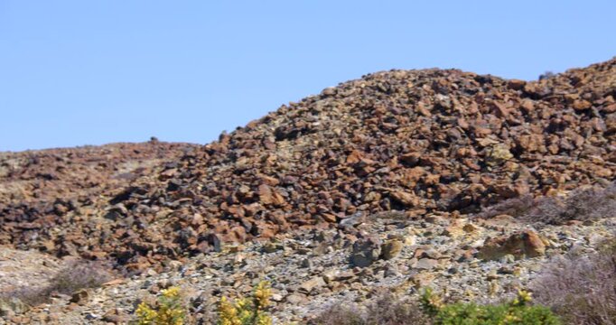 Slow zoom in to the roasted ore slag heap at mynydd parys mountain copper mine.