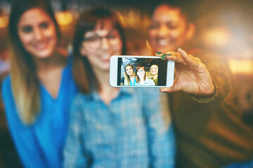 Phone screen, group and selfie of friends with hand in cafe for happy memory, social media or...