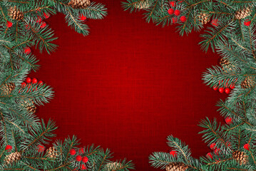 Holiday background with a festive frame of pine branches, cones, and red berries on red canvas texture. Perfect template for Christmas greeting cards, winter sale banners, or festive invitations.