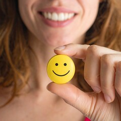 smiling woman holding a a yellow smile icon
